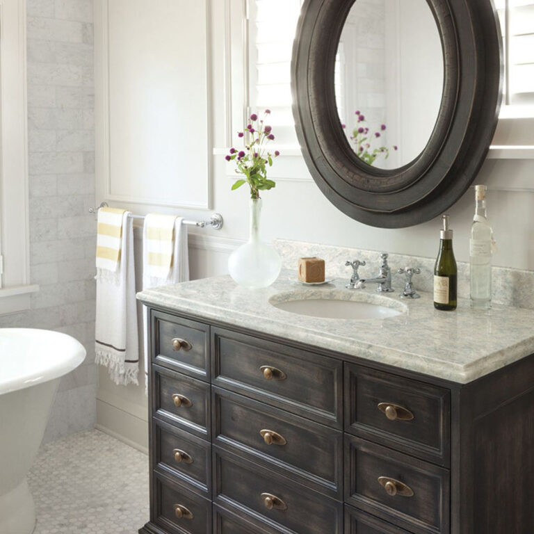 Modern farmhouse bathroom with dark vanity and matching round mirror